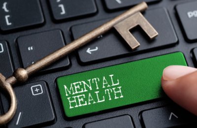A photo of a key on a laptop keyboard. One of the buttons reads 'Mental health' and is colored green. 