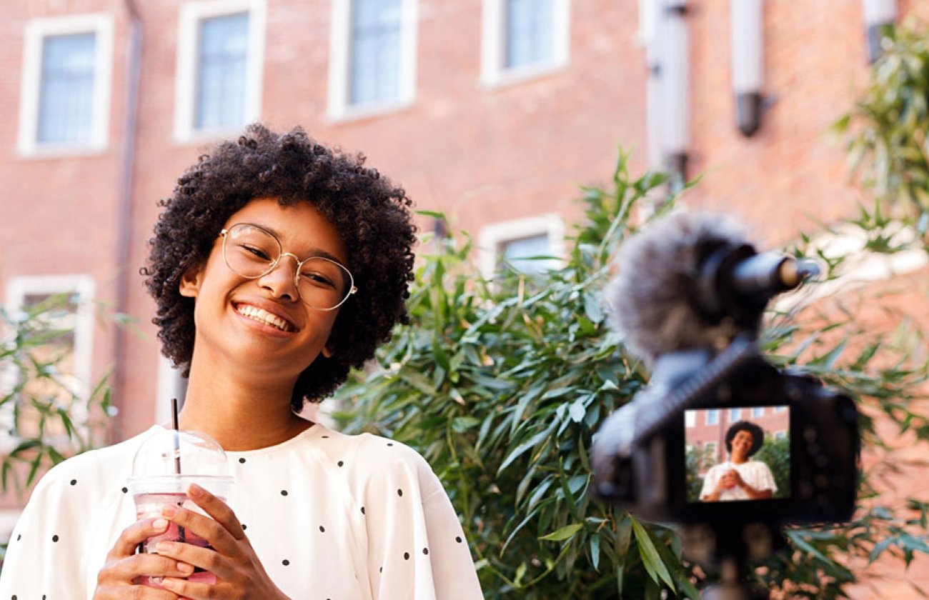 Photo of a person in front of a camera smiling