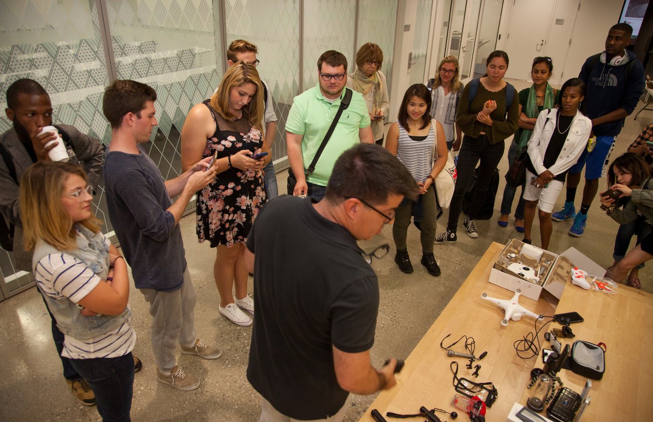 USC Annenberg professor Vince Gonzales (foreground, center) shows journalism graduate students an array of devices that enhance their phones for mobile journalism during the Summer Immersion boot camp. © USC Annenberg/Brett Van Ort