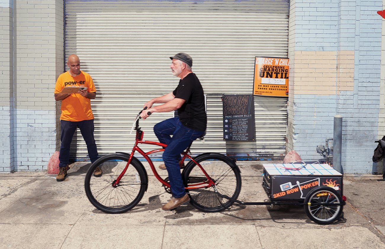 Photo of François Bar, professor of communication, pulling a solar-paneled cart designed to provide power to Skid Row residents’ mobile phones