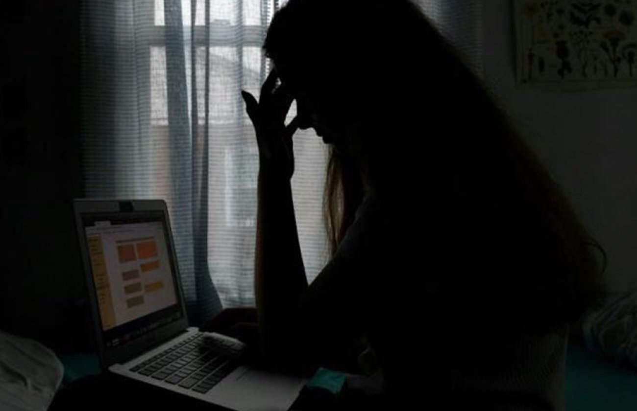 A student in distress looking at a laptop