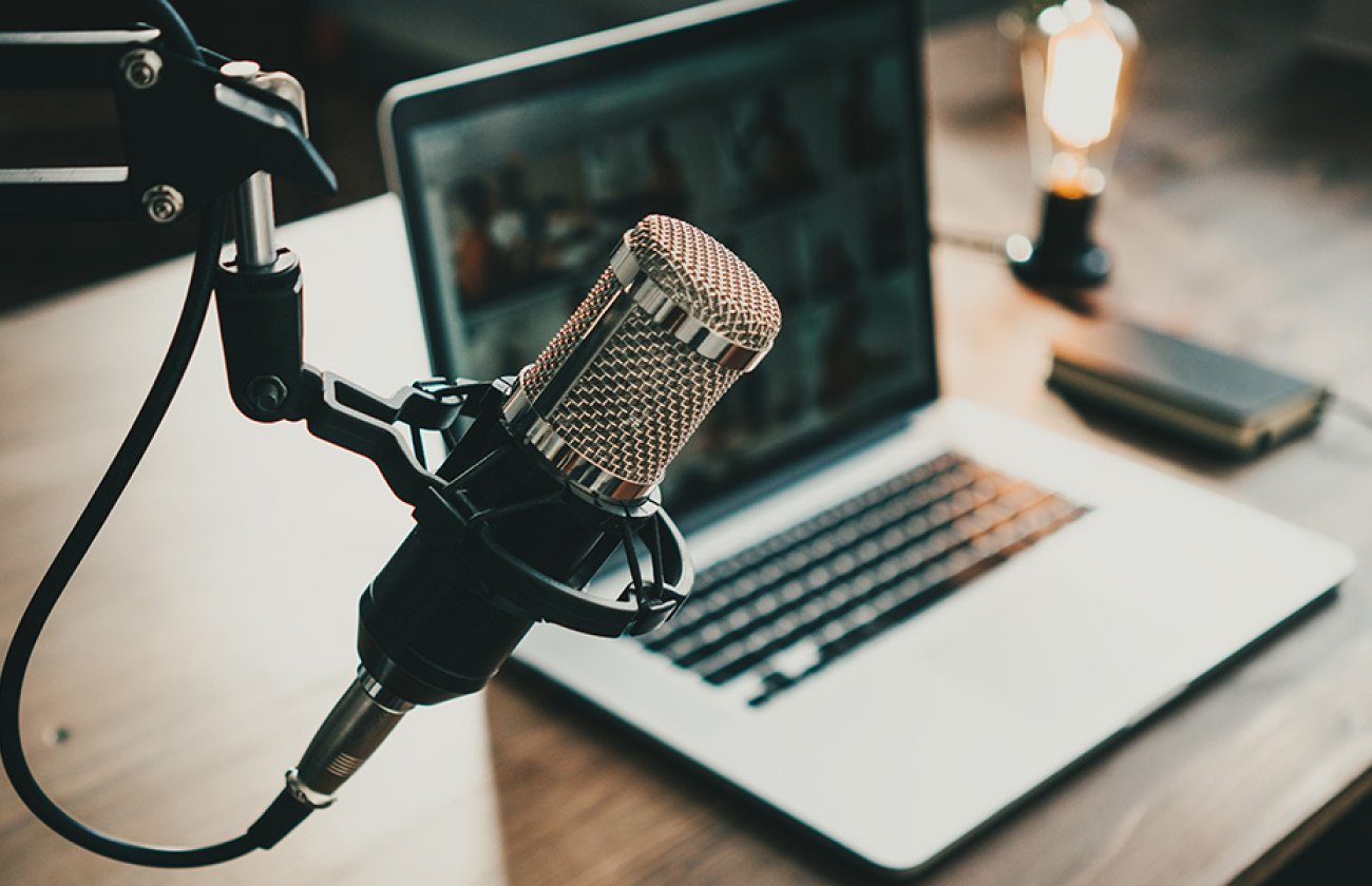 Desk with laptop and podcast microphone. 