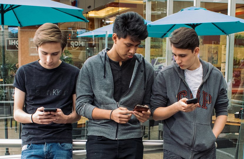 Photo of teenagers using cellphones