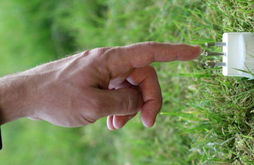 Photo of a hand touching a wall electrical cube