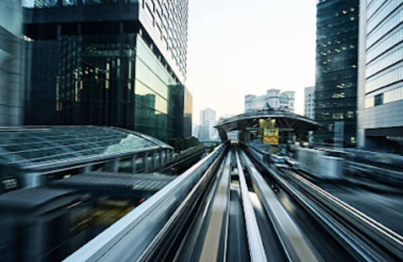 A tram moving quickly on a track in a futuristic city