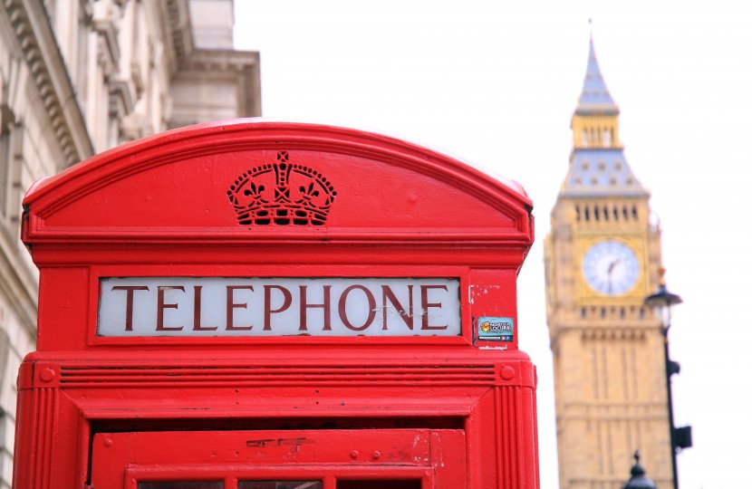 Photo of a red telephone booth next to the Big Ben in London