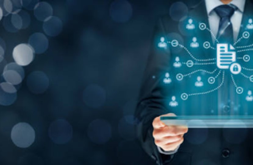A person in a suit holding a tablet with floating glowing blue icons of people and documents above it