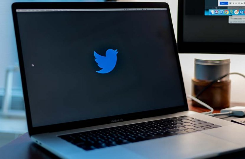 Photo of a laptop screen with the Twitter logo on it