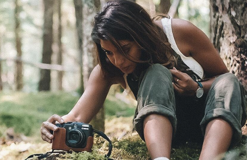 Photo of Aliya Jasmine taking a photograph in a forest