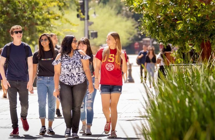 5 students walking and talking at USC