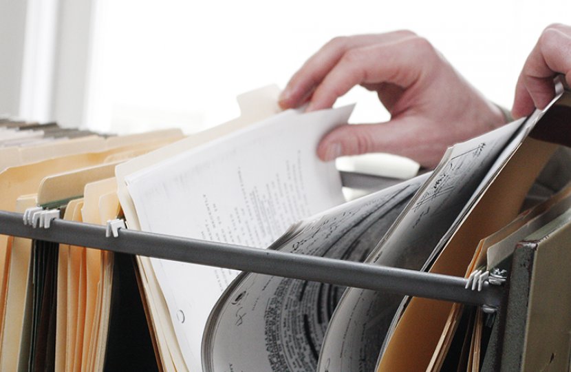 Photo of a person flipping through files in a cabinet