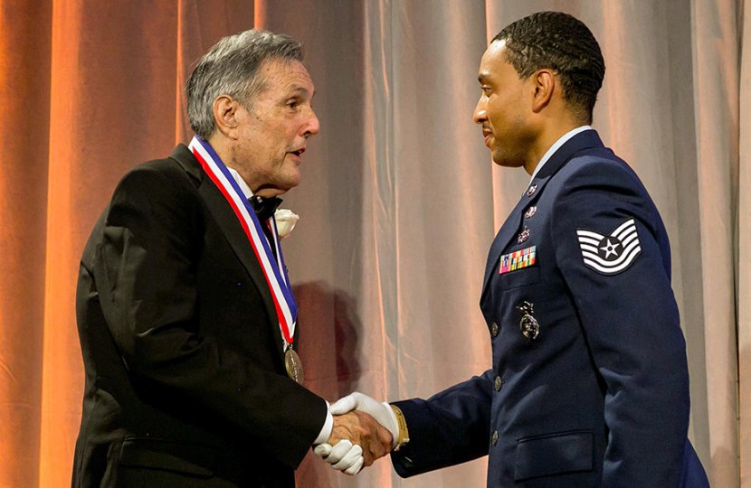 Jeff Cole (pictured left) shakes Air Force officer's hand and receives medal