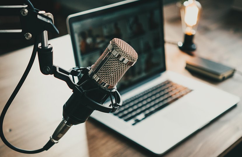 Desk with laptop and podcast microphone. 