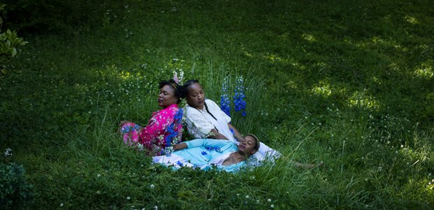 Three people laying in grass