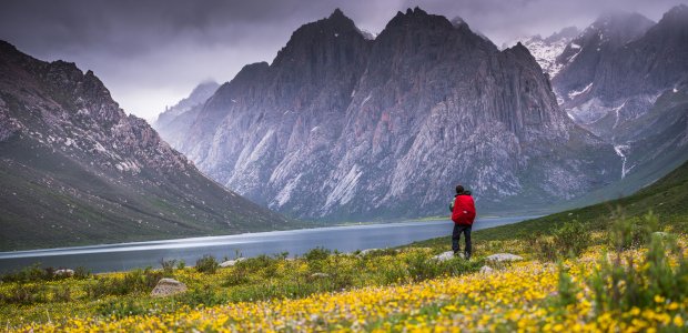 Photo of a mountainous landscape and a person standing in the right of the photo
